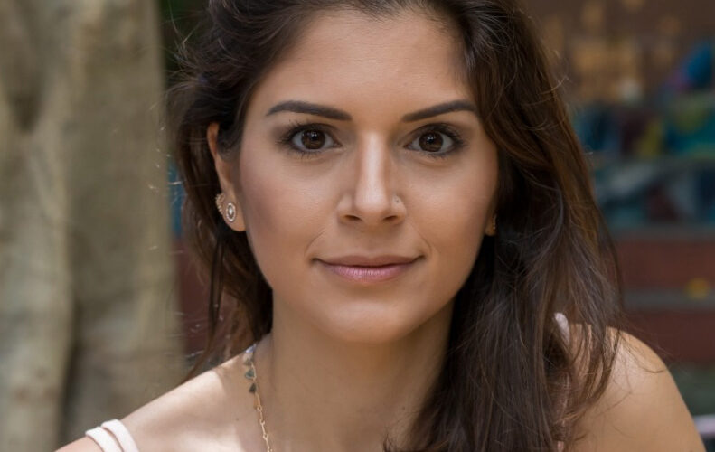 Mulher branca de cabelos longos e castanhos soltos.