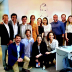 Foto de grupo de pessoas olhando sorrindo para foto.
